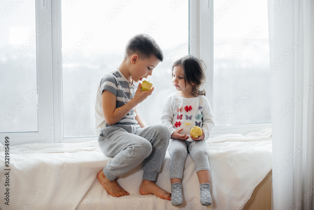 An image of two children talking to one another sitting on their bed